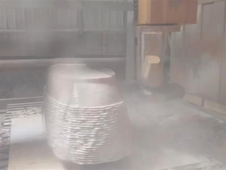 Five-axis machining center wet-cutting a client-approved Calacatta marble block according to the approved bathtub 3D model.