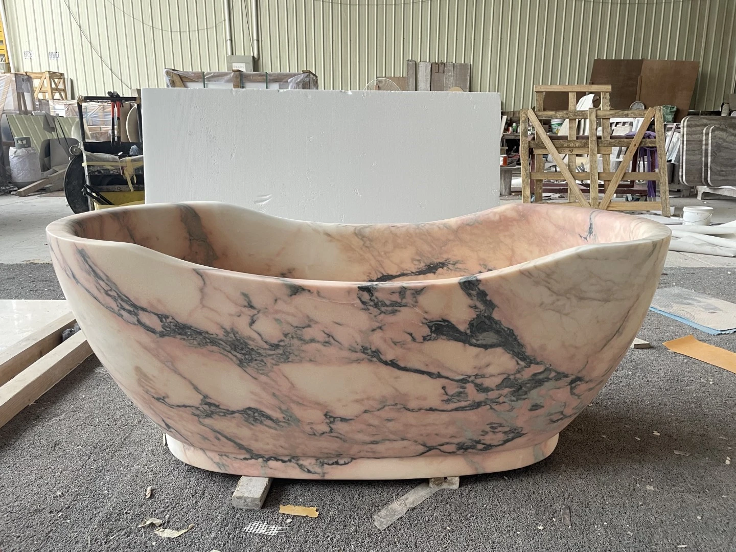 Finished freestanding Calacatta Rosa marble bathtub with a sculpted asymmetric rim, rounded body and prominent pink and dark gray veining. Finished freestanding Calacatta Rosa marble bathtub with a sculpted asymmetric rim, rounded body and prominent pink and dark gray veining.