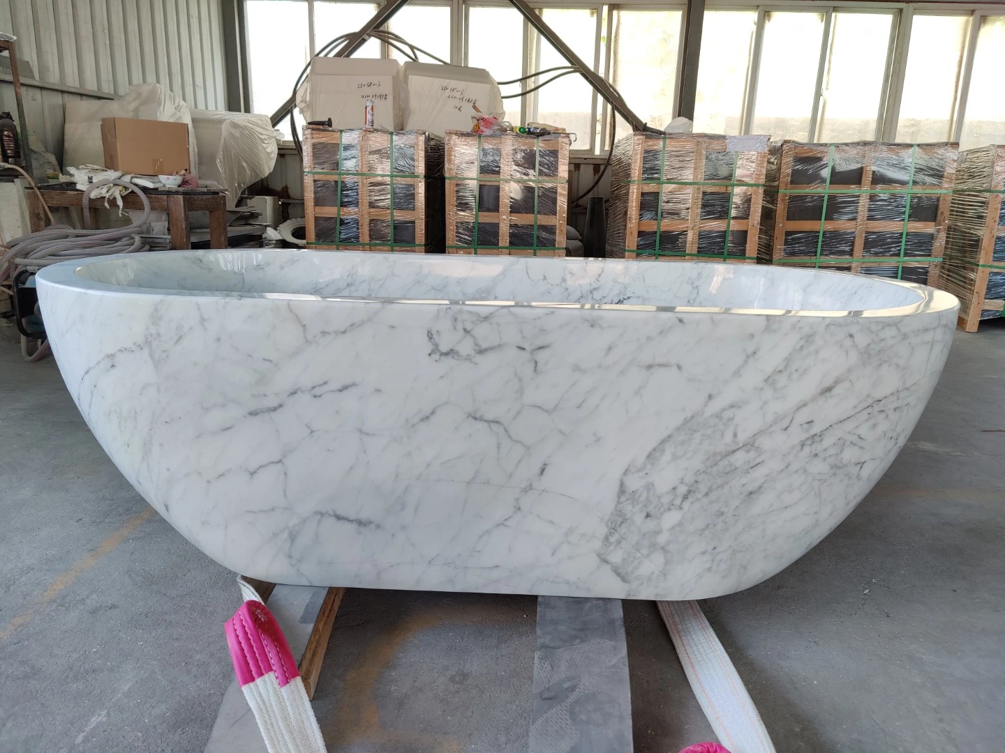 Finished freestanding Calacatta marble bathtub with a polished white surface and natural gray veining in the Landiview Stone workshop. Finished freestanding Calacatta marble bathtub with a polished white surface and natural gray veining in the Landiview Stone workshop.